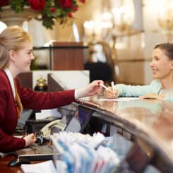 woman signing a document at the reception desk